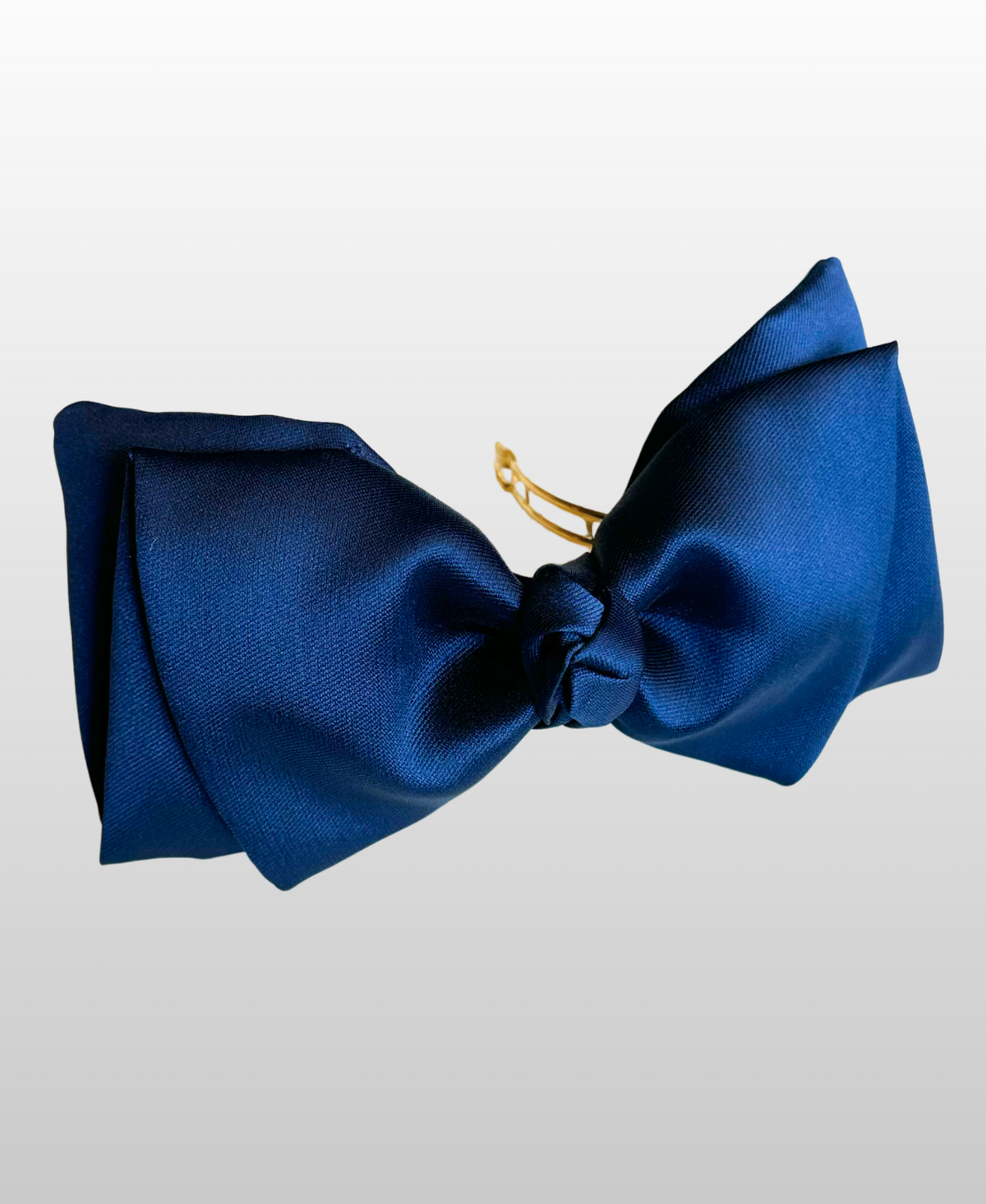 Nœud en polyester recyclé de couleur bleue marine, monté sur une barrette dorée à l'or fin.
