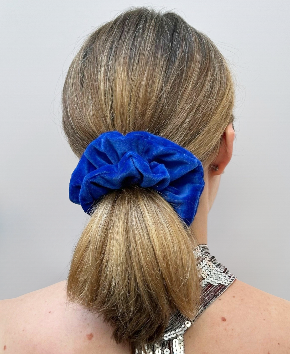 Le chouchou Nicole en velours de coton bleu roi, porté sur une épaisse chevelure blonde.