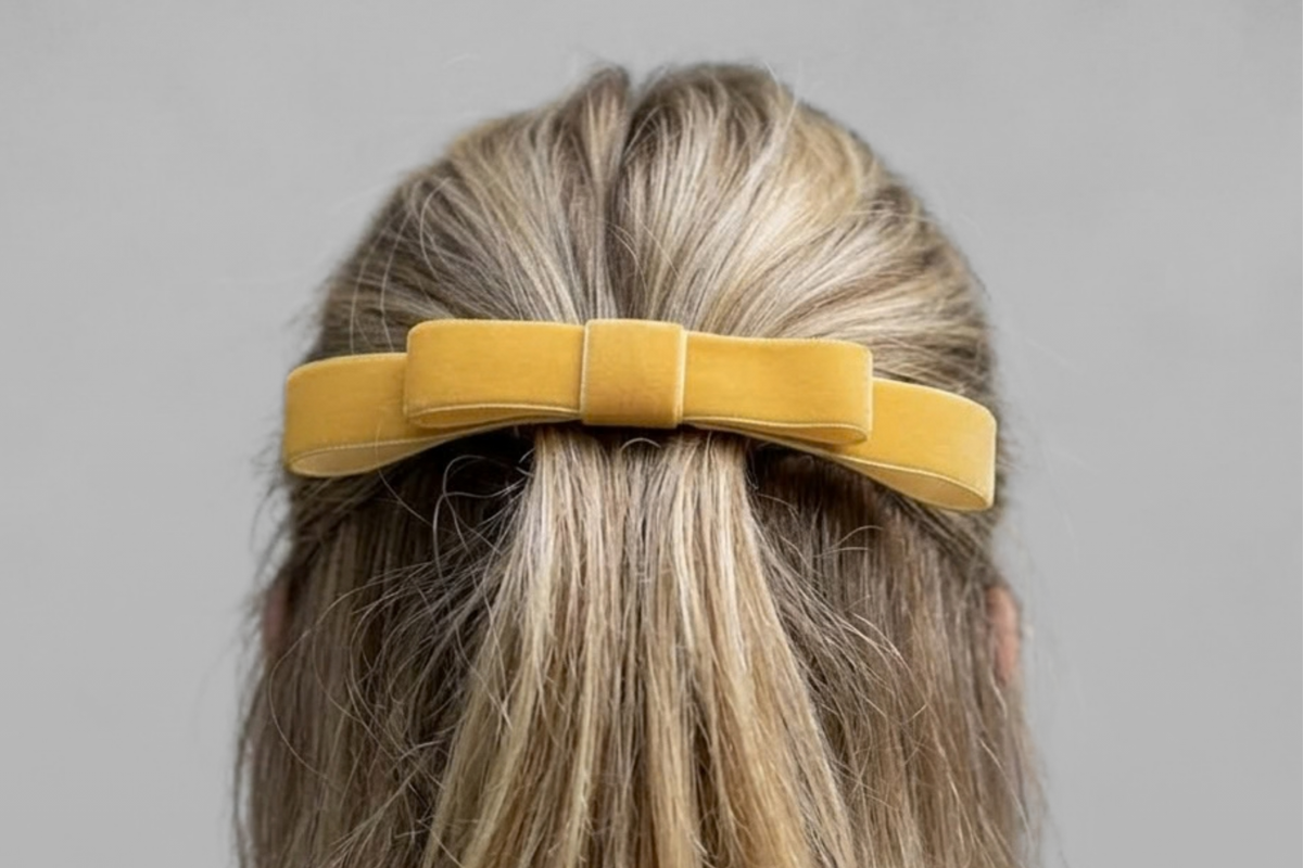 Nœud minimaliste jaune tournesol, porté en demi-queue sur une chevelure blonde.