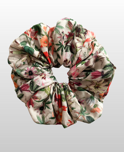 Chouchou au motif floral élégant dans des teintes harmonieuses de violet, vert, corail, orange, sur un fond beige clair, 100% coton français.